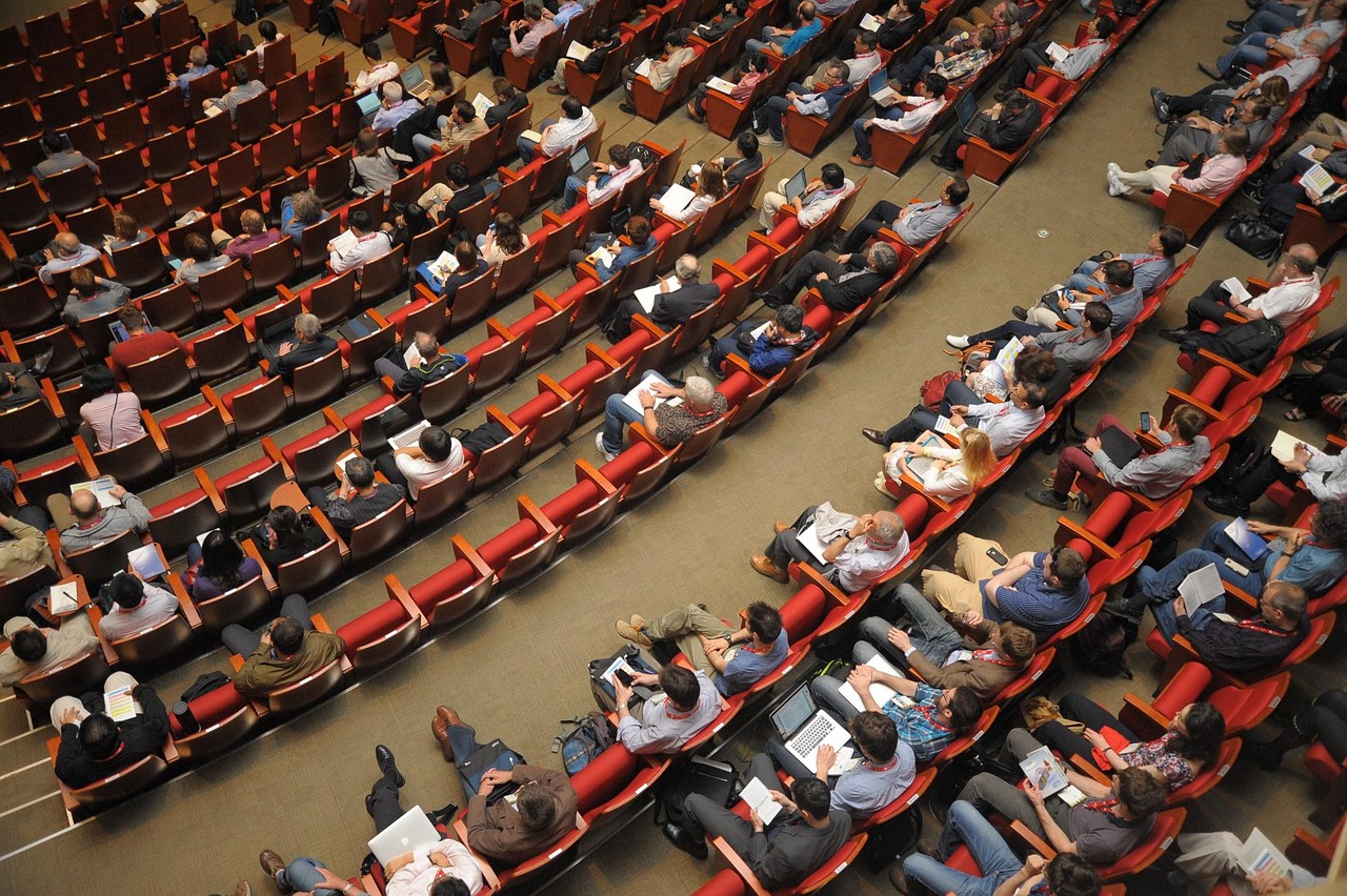 Salón acondicionado con sillas en fila para una asamblea presencial